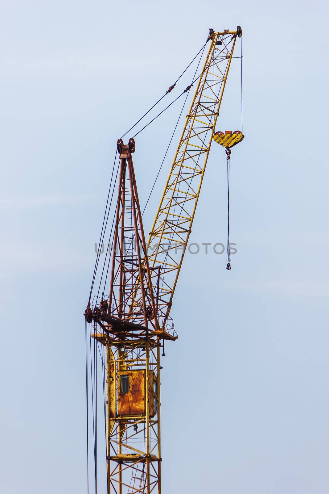 Building hoisting crane against the blue sky