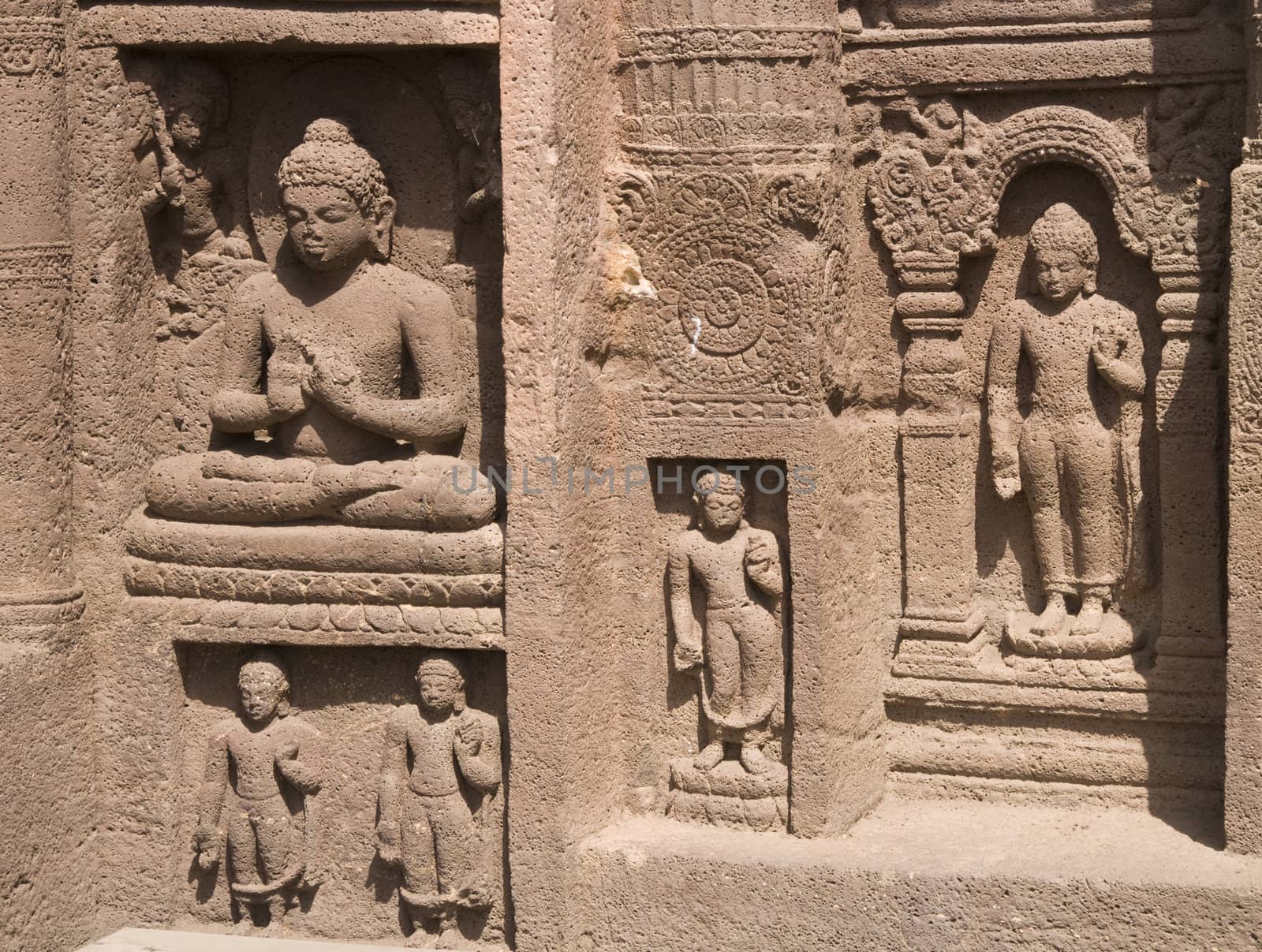 Religious figures carved out of the rock on the facade of an ancient Buddhist cave temple Ajanta Caves near Aurangabad India. 5th-6th Century AD