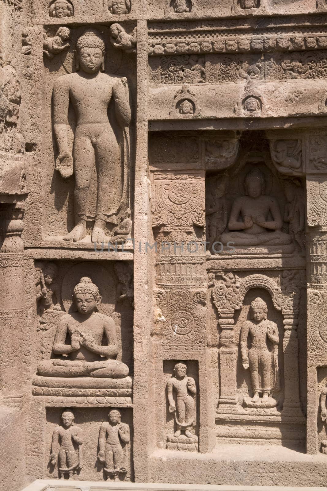Religious figures carved out of the rock on the facade of an ancient Buddhist cave temple Ajanta Caves near Aurangabad India. 5th-6th Century AD