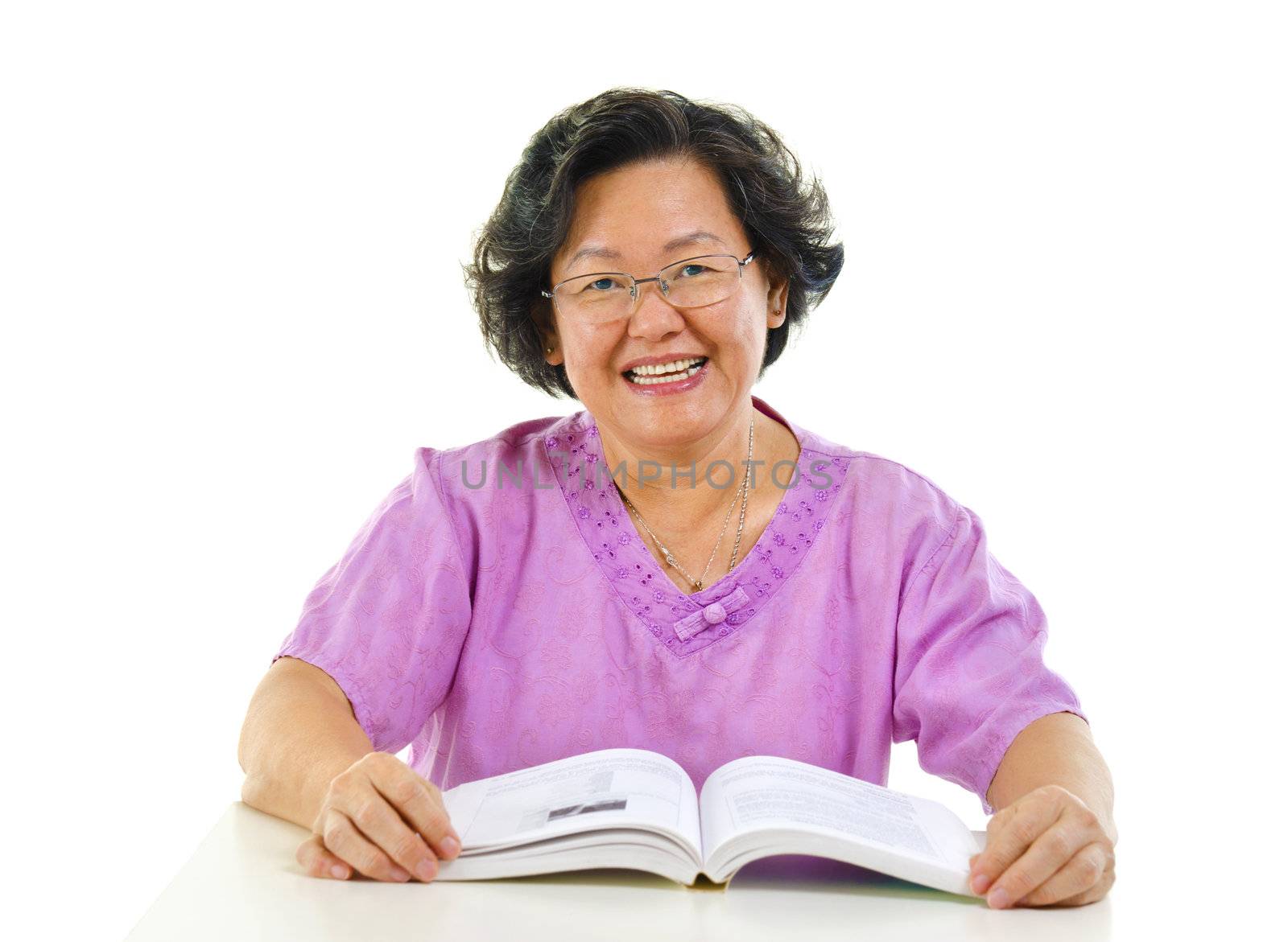 Asian senior woman reading book over white background