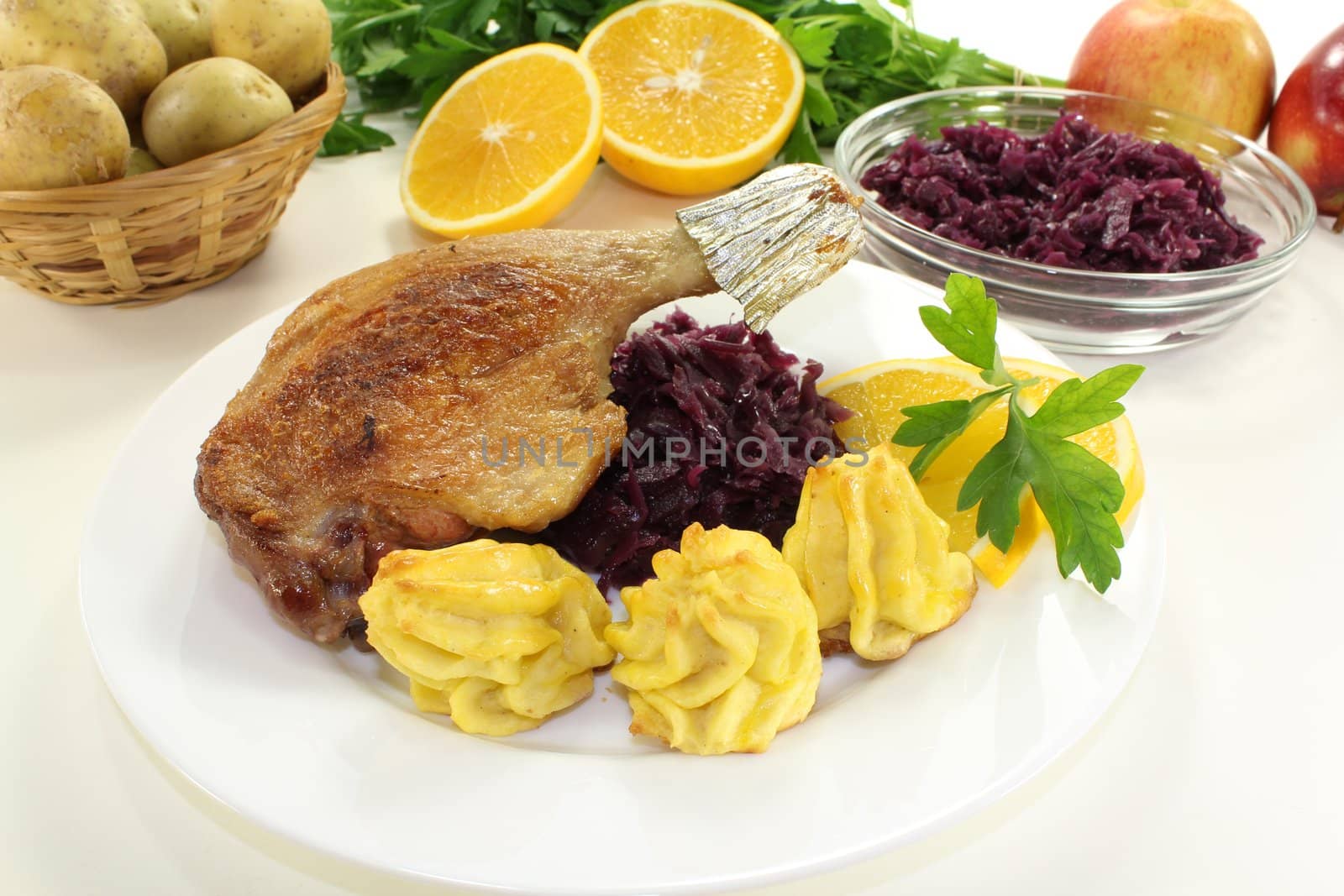 delicious Duck drumstick with duchess potatoes and red cabbage on a bright background