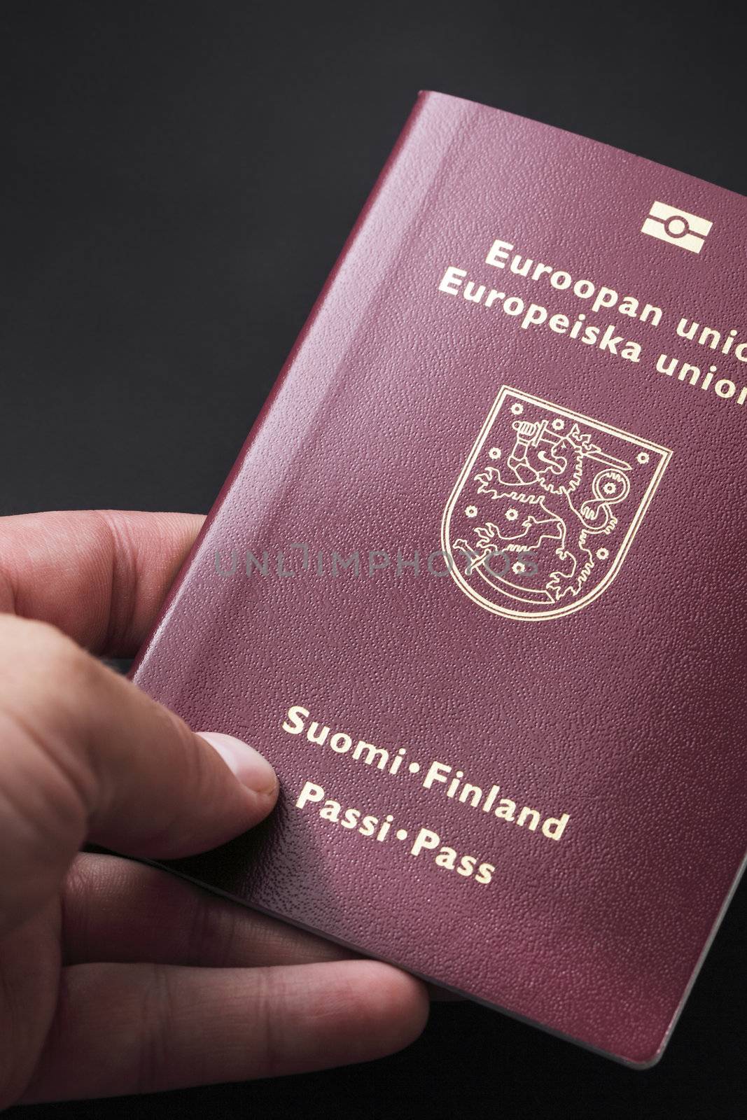 Man holding finnish passport in his hand.