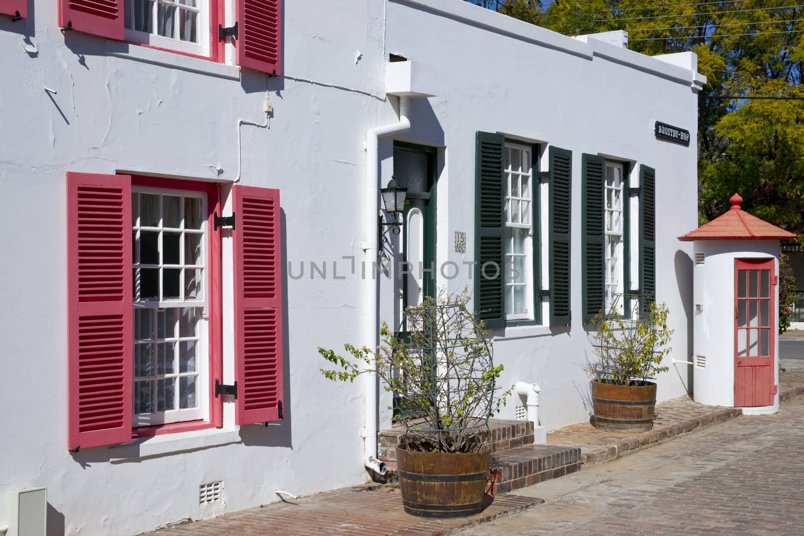 Historic architecture in Graaff-Reinet, Eastern Cape, South Africa. White building in Cape Dutch style with colorfully painted window frames.