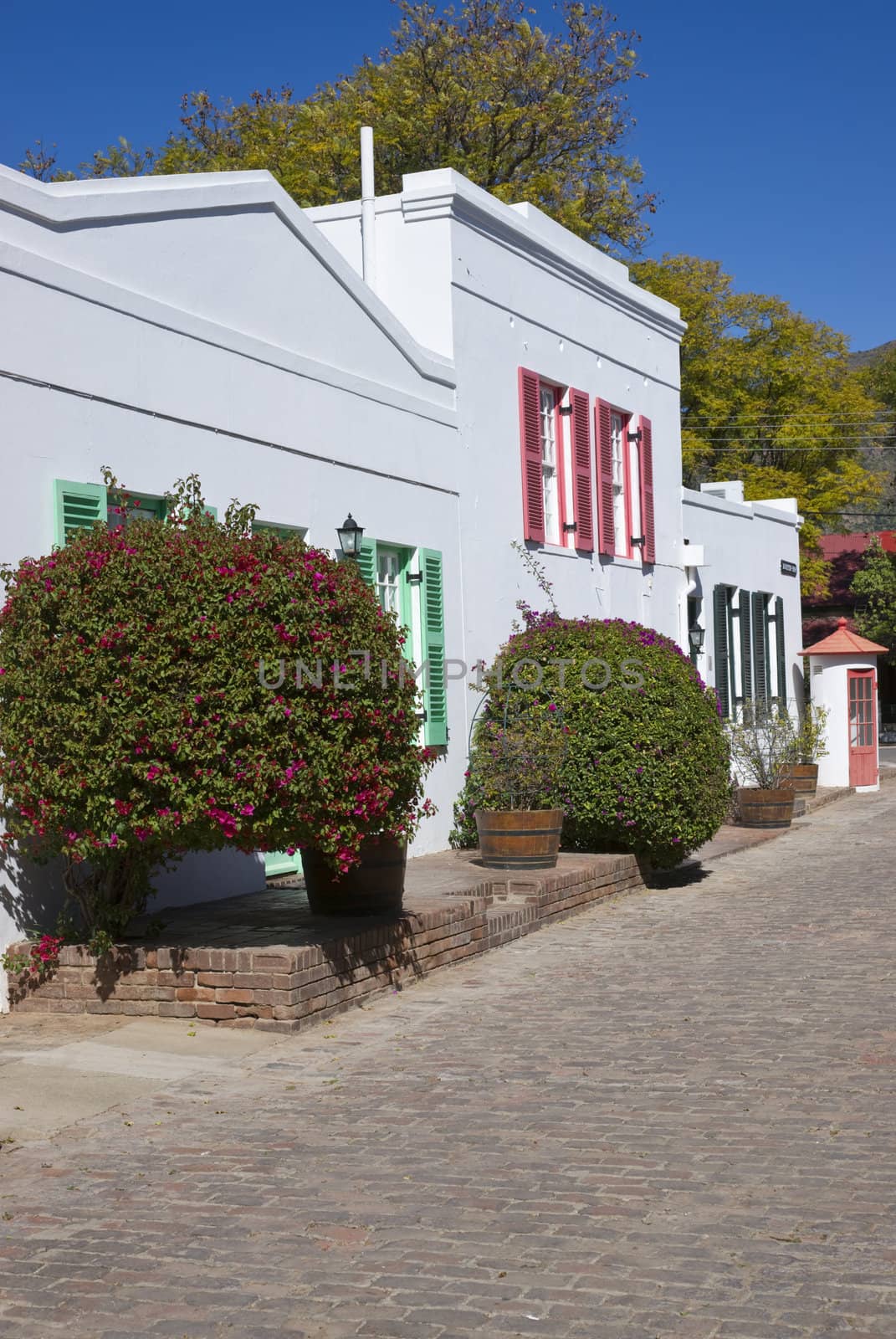 Historic architecture in Graaff-Reinet, Eastern Cape, South Africa. White building in Cape Dutch style with colorfully painted window frames.