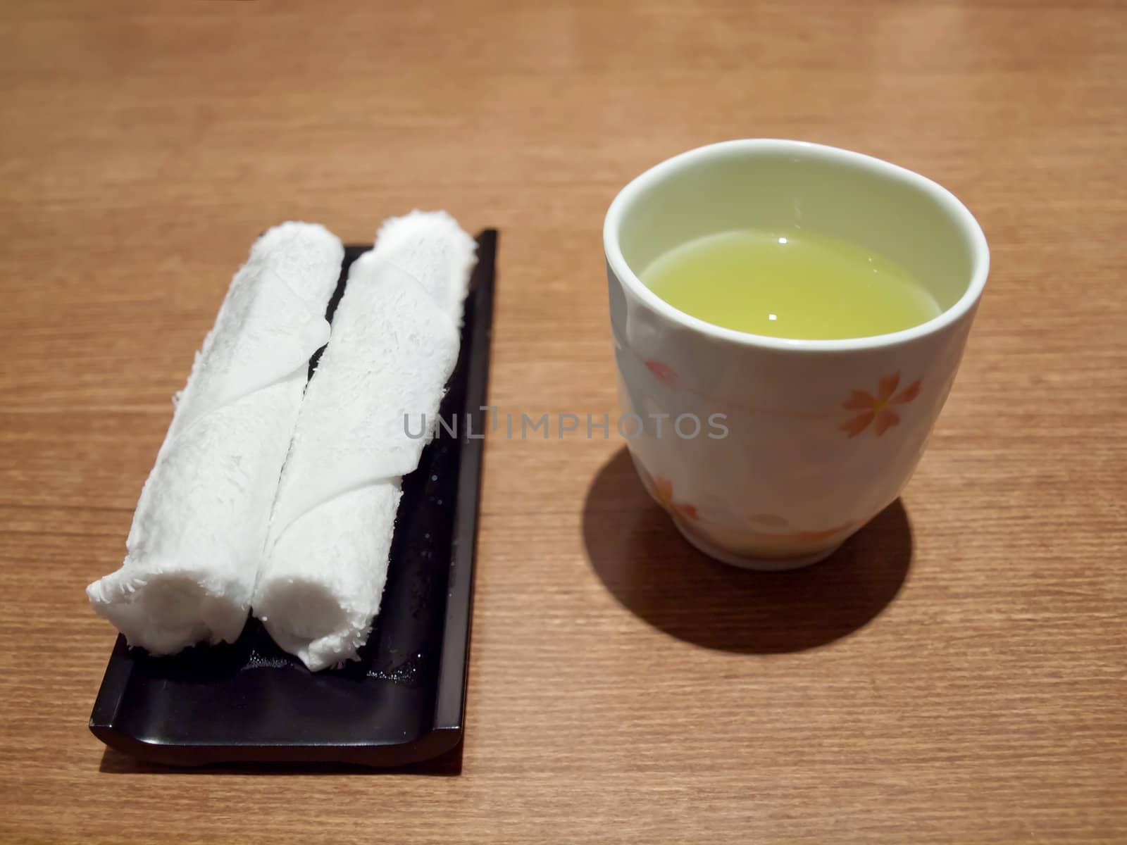 Teacup with roll of hand towel for cleaning your hand before meal time