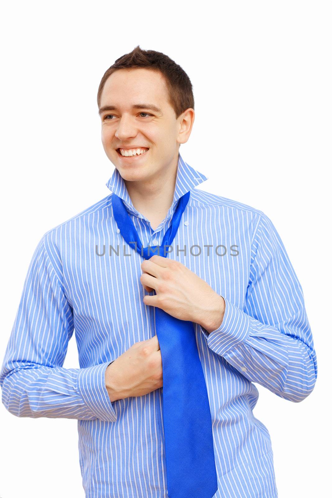 Young businessman at home preparing for a work and making his tie