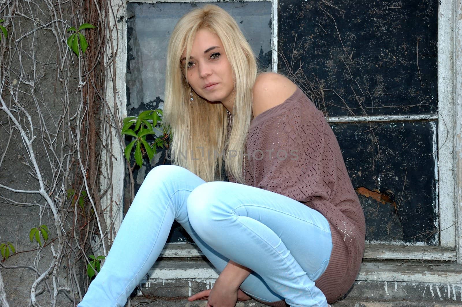 Young female model wears casual clothes. Sits near window with natural face expression, teenage girl cool and relaxed.