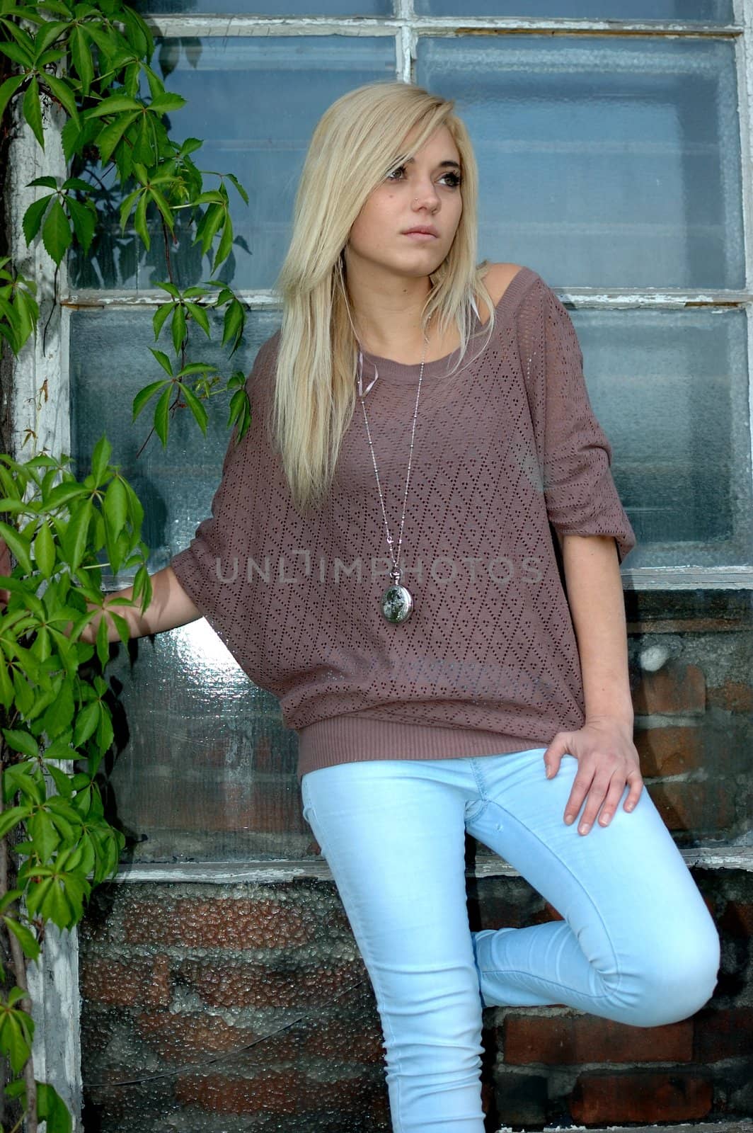 Young female model wears casual clothes. Teenage girl cool and relaxed standing near the window.