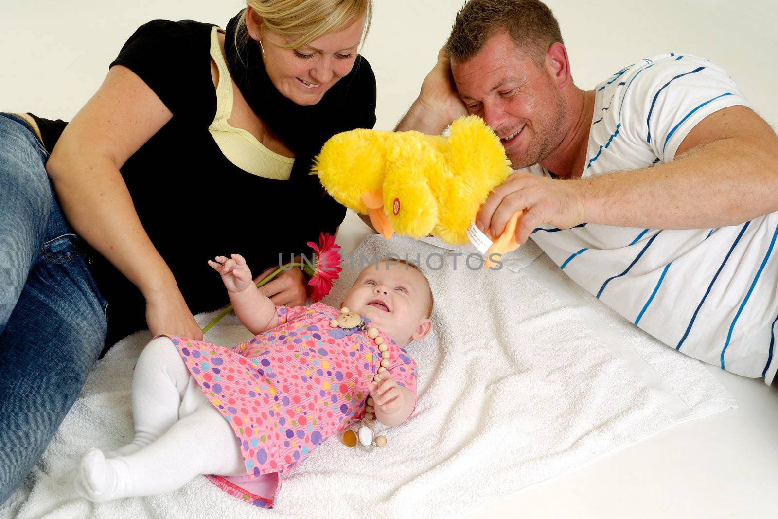 Happy family playing. Mother and father are looking at their sweet smiling 4 month old baby.