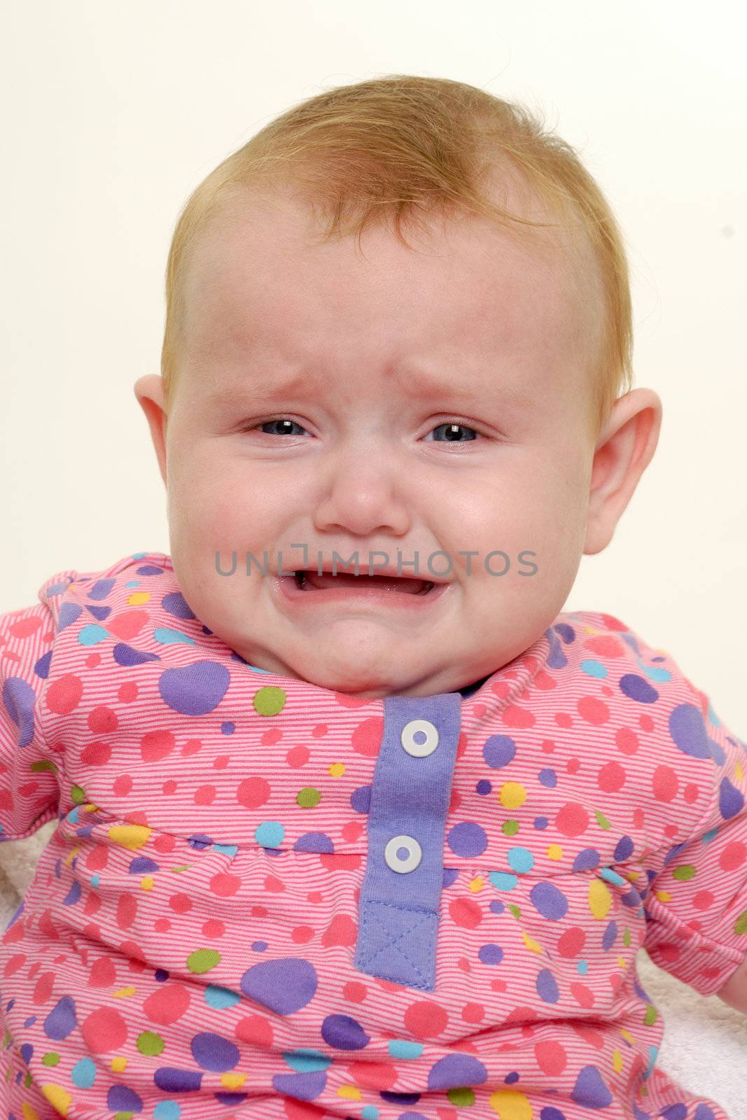 Sad baby is crying. Isolated on a white background.