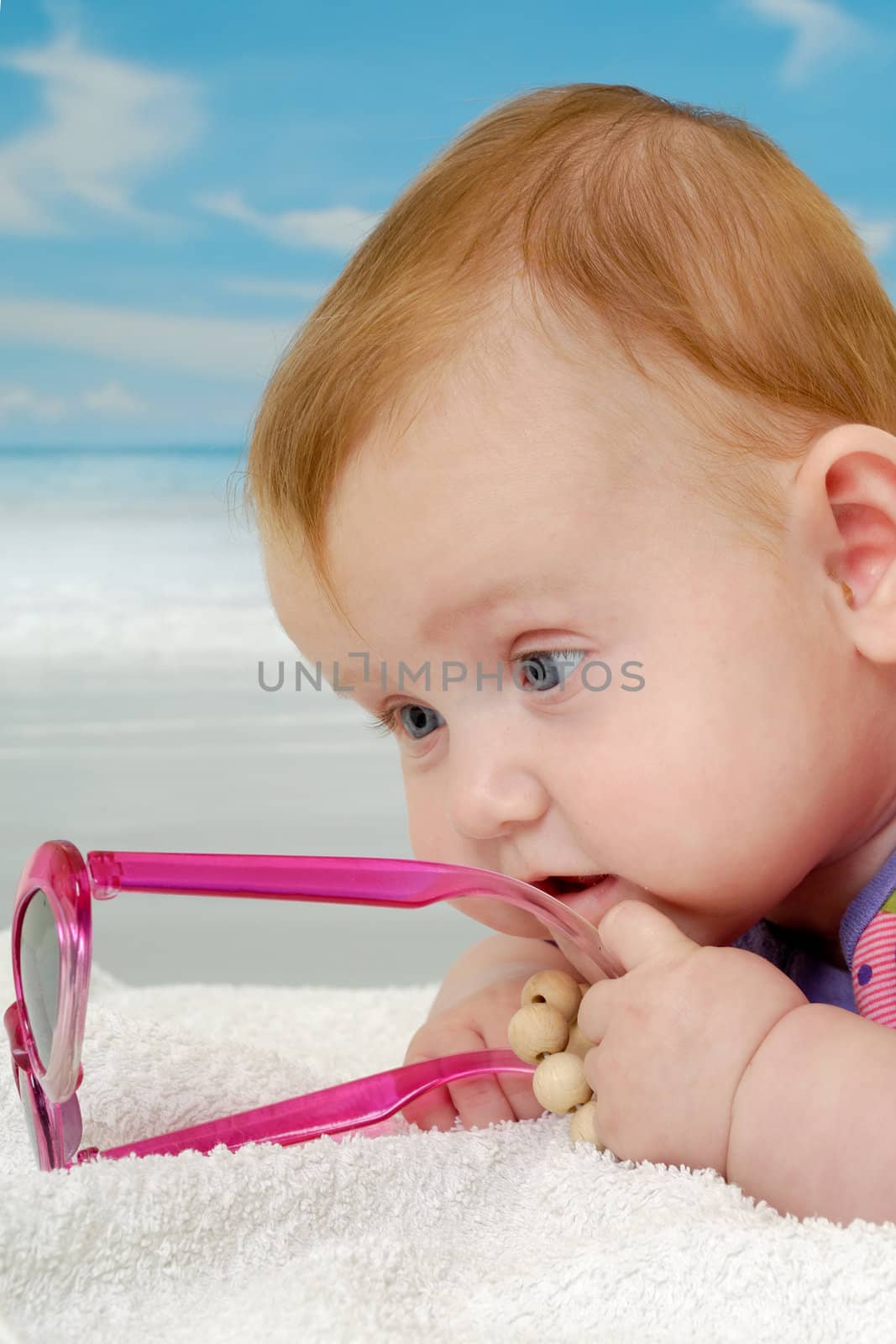 Sweet baby on vacation on beach with the sea in the background.