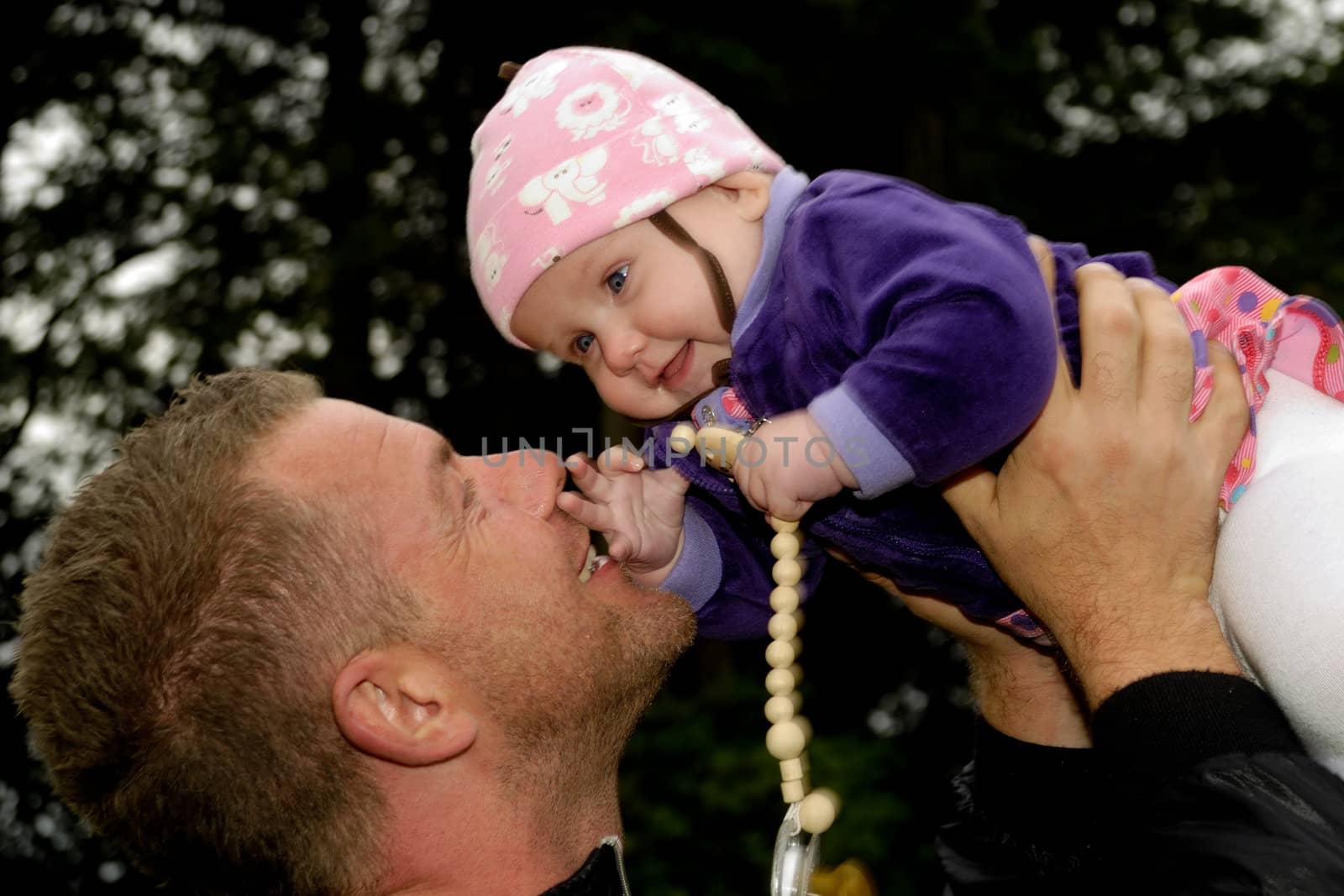 Happy father is lifting up his smiling baby
