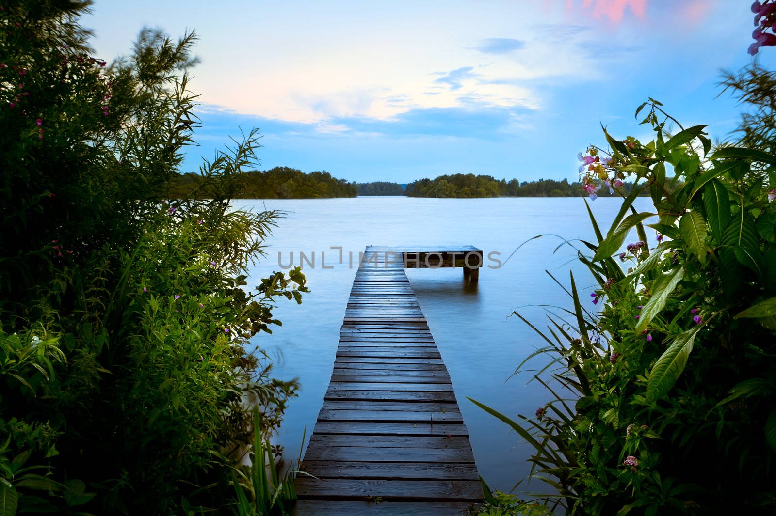 wooden pier in summer on lake by catolla