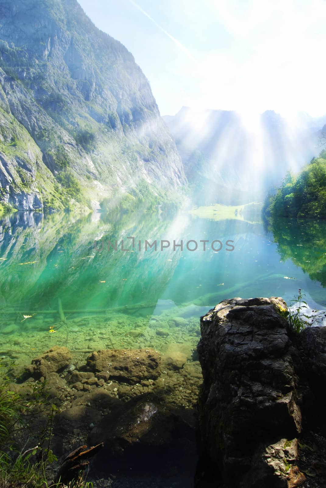 Alpine lake with sun rays by fyletto