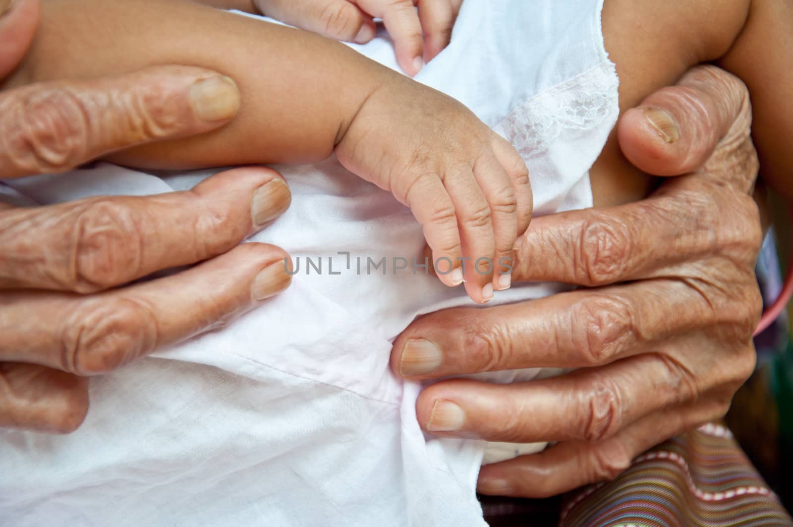 old woman and baby hand