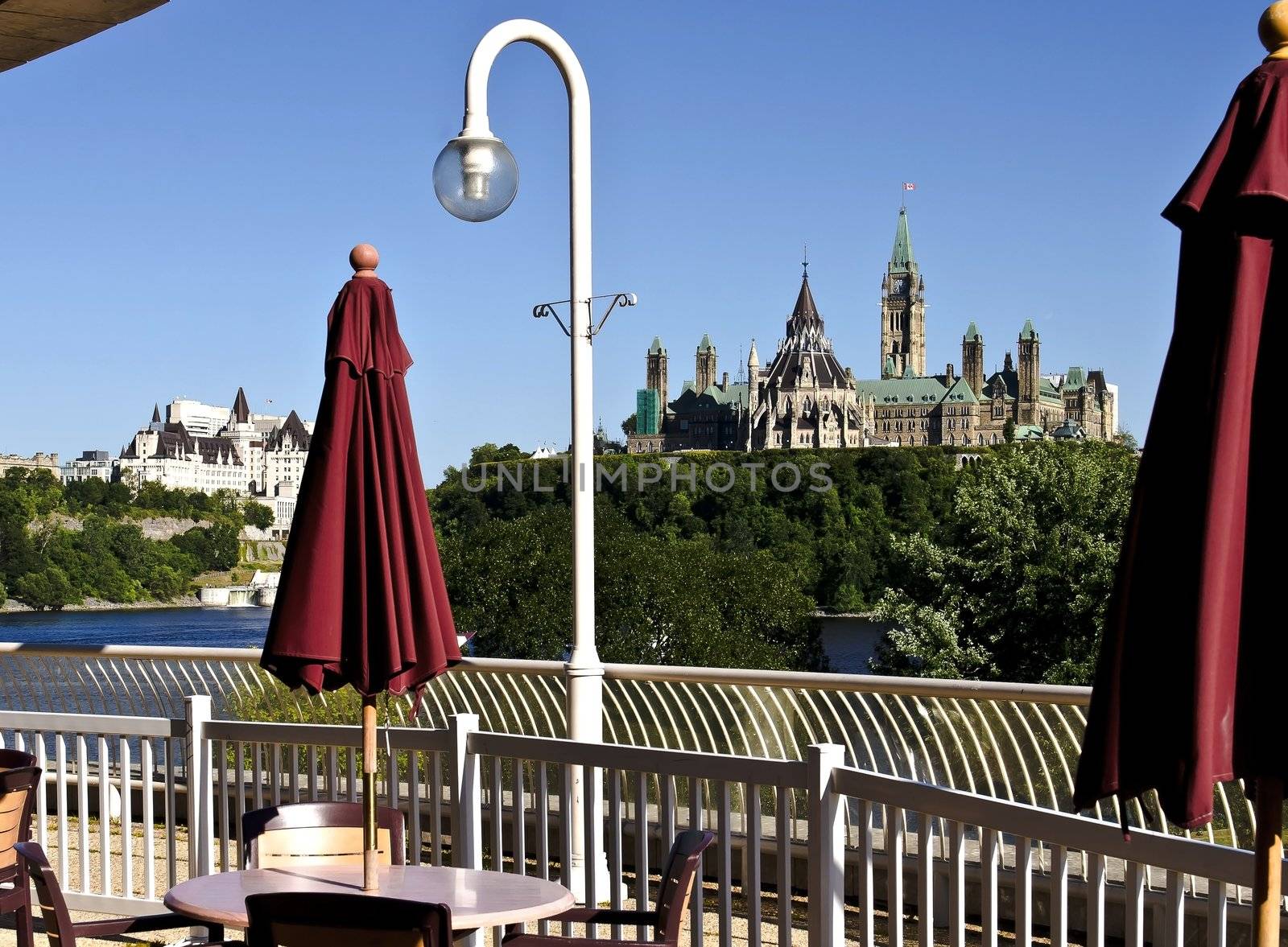 The canadian Parliament Centre block and Library seen from a patio across the Ottawa river.
