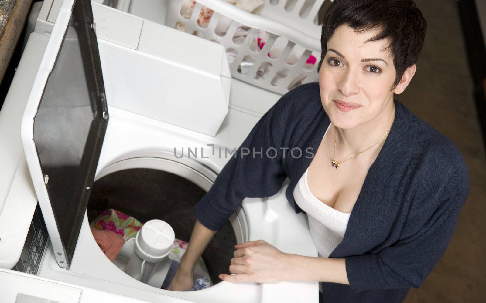 A woman pulls clothes from the washer at the laundromat