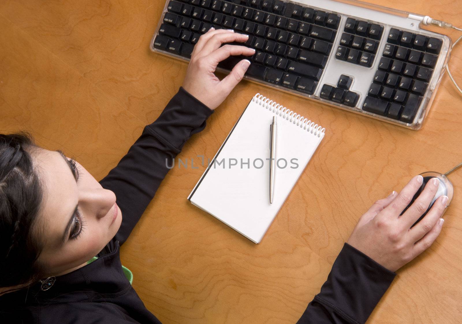 A woman in black enter data on a keyboard