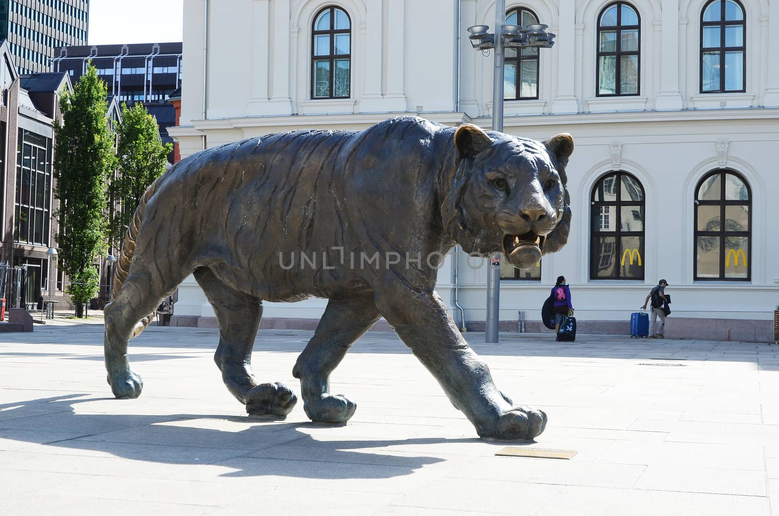 A statue of a tiger standing on the square in front of the central station in Oslo, Norway