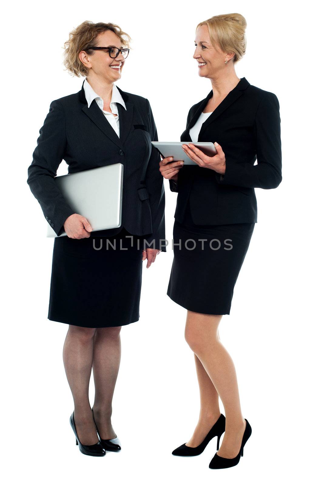 Full length portrait of two businesswomen discussing business isolated over white