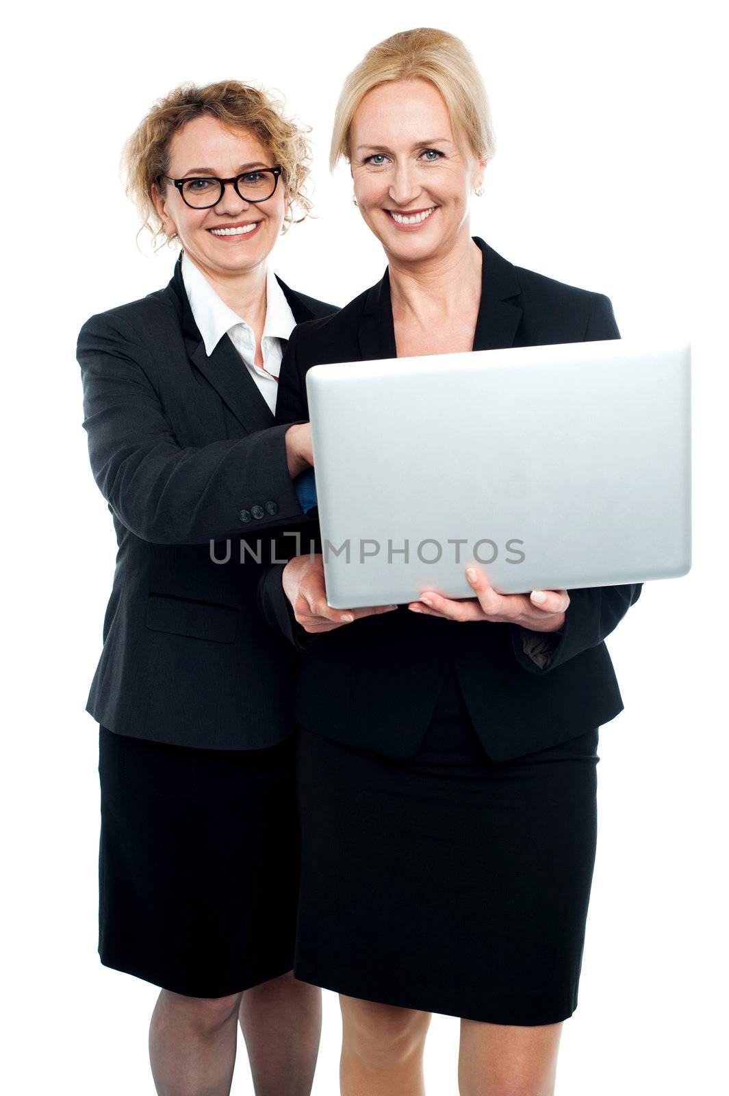 Cheerful corporate ladies using laptop isolated over white background