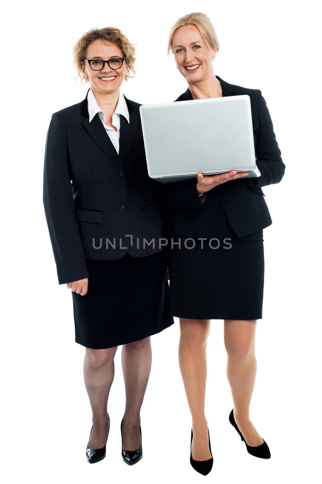 Full length portrait of senior businesswomen posing with laptop isolated against white background