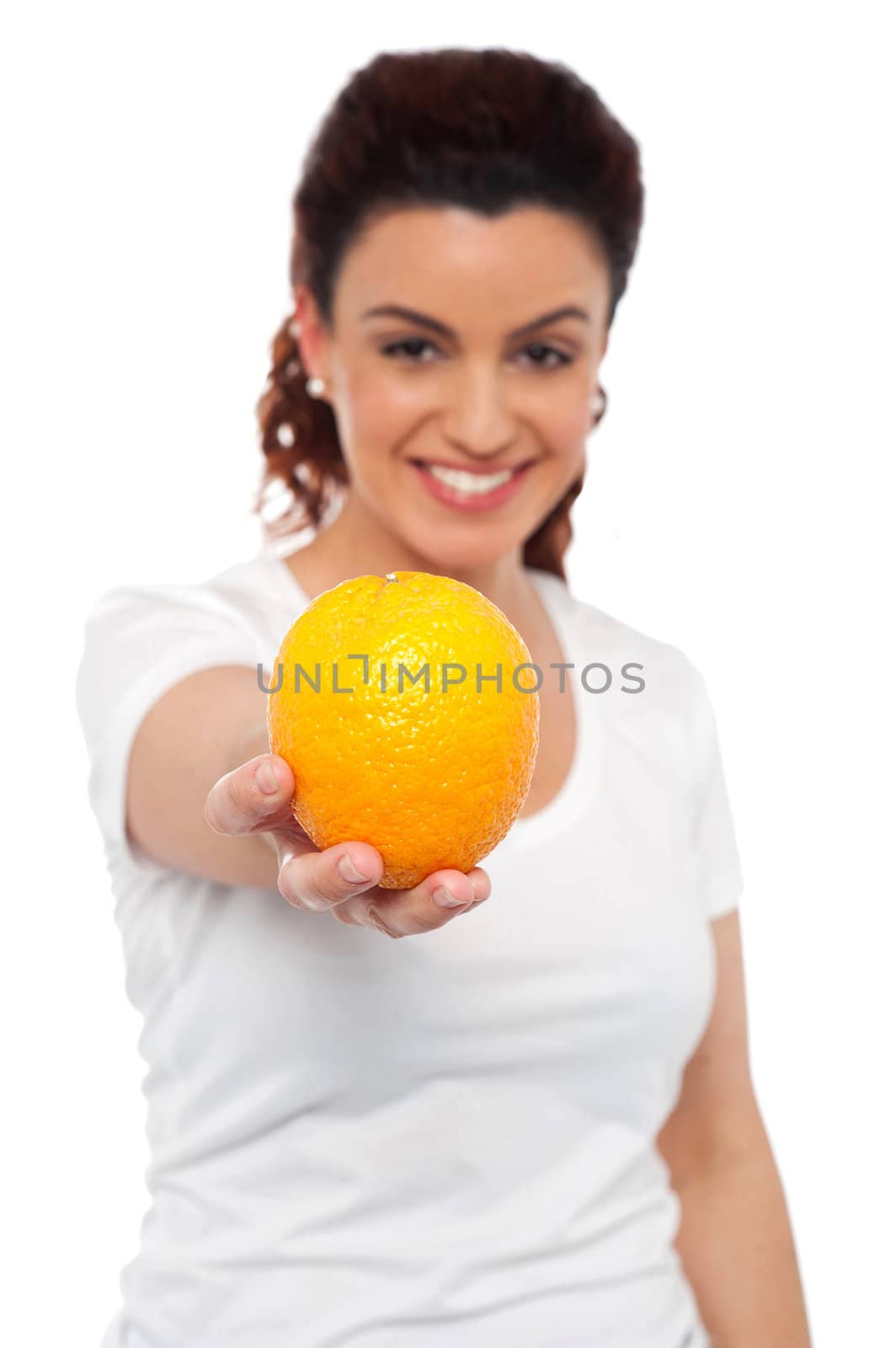 Smiling beautiful woman offering you an orange. Eat healthy, stay fit