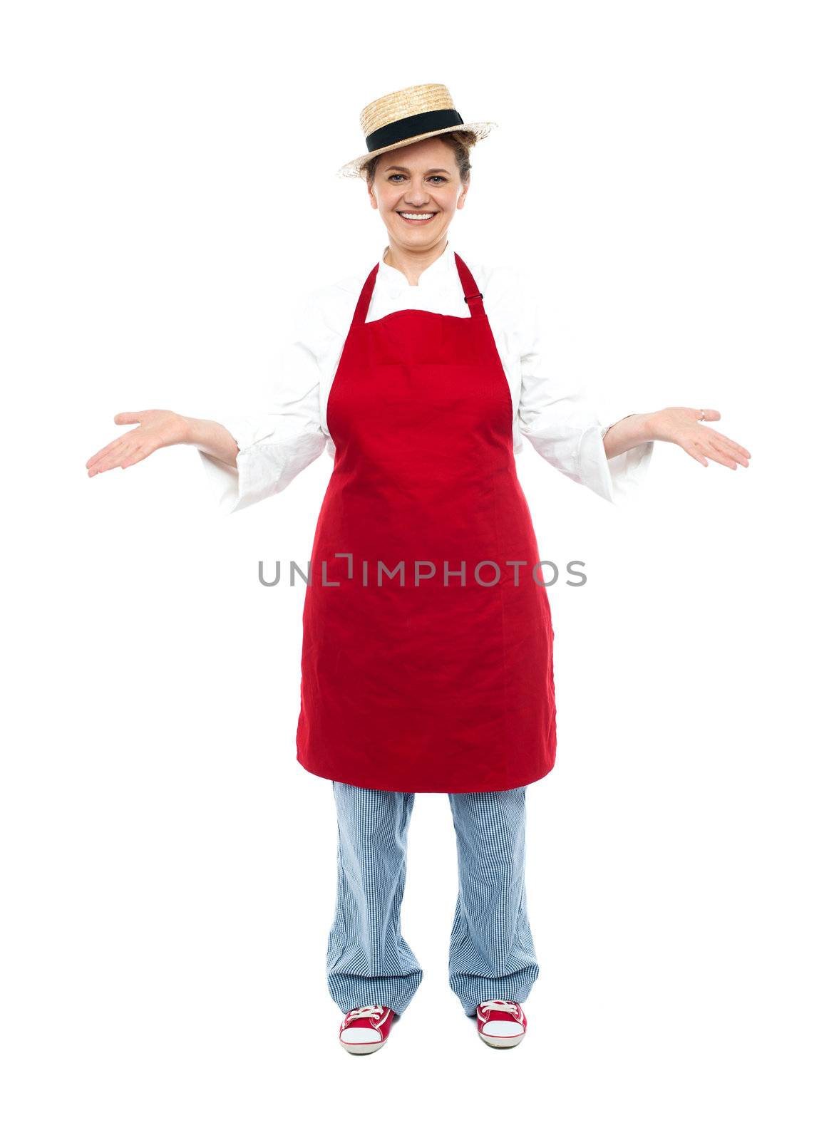 Cook posing with open palms welcoming you, full length portrait