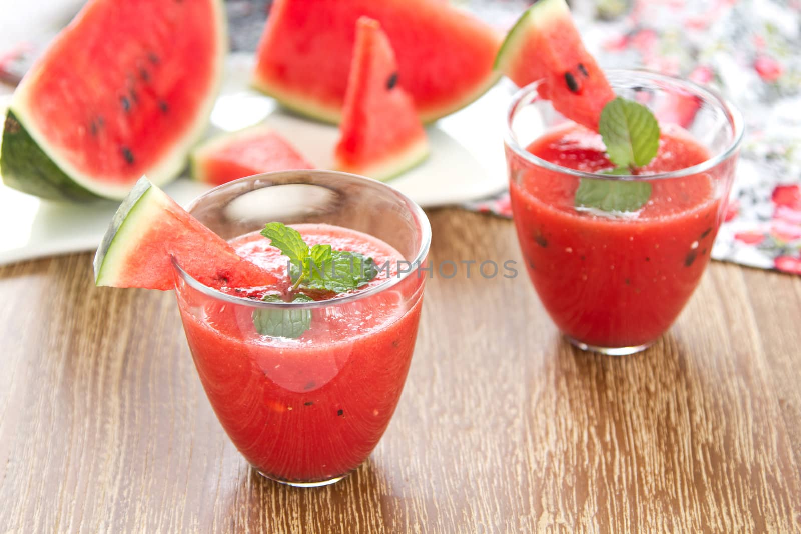 Fresh Watermelon smoothie with mint on top by some fresh pices of watermelon