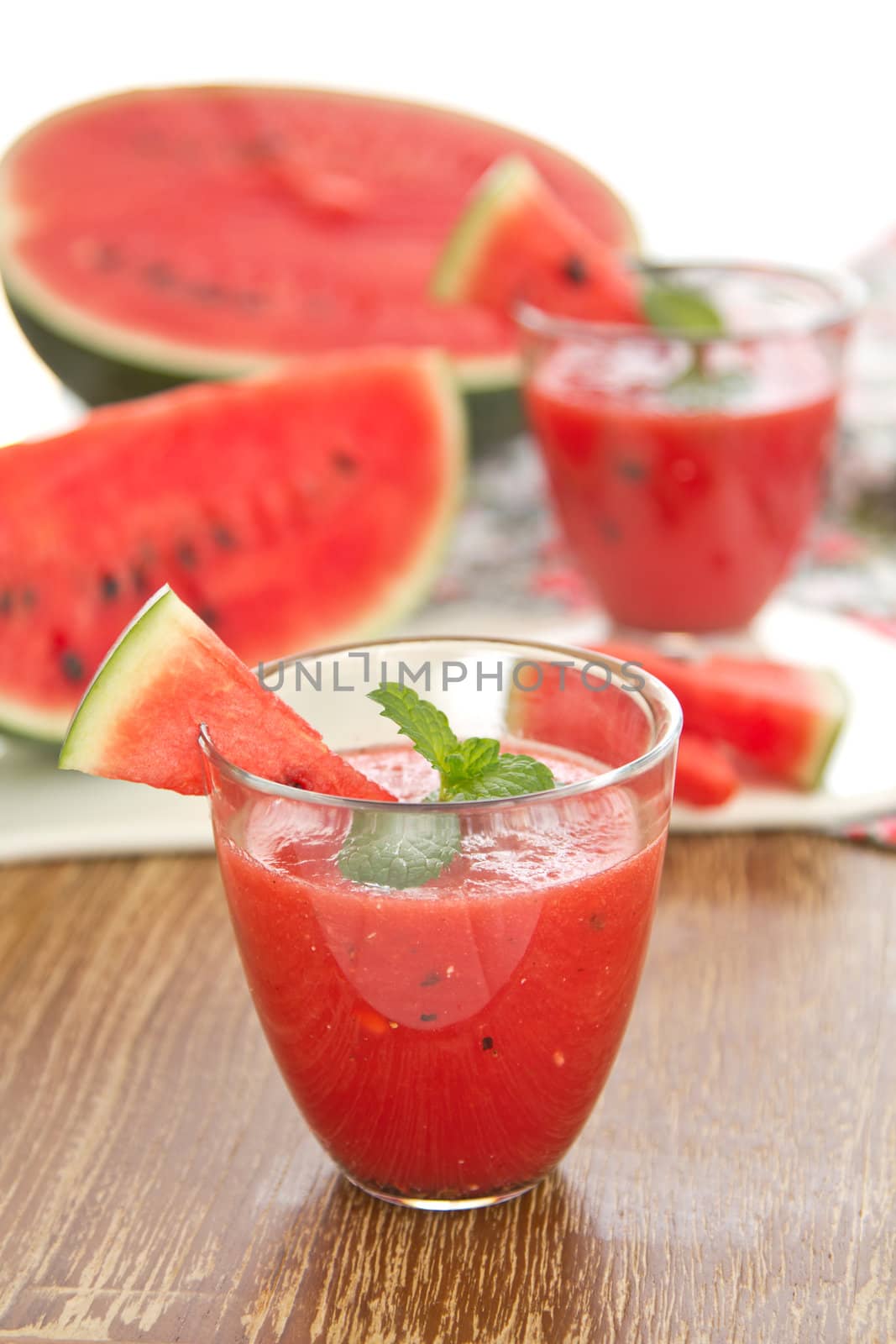 Fresh Watermelon smoothie with mint on top by some fresh pices of watermelon