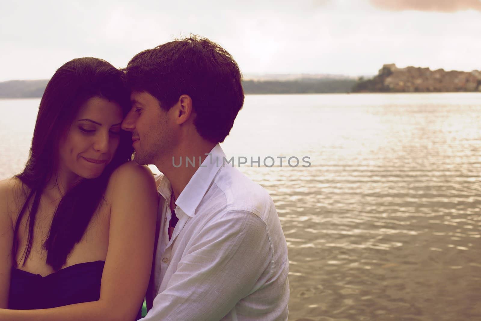 Couple in love on a lake during sunset