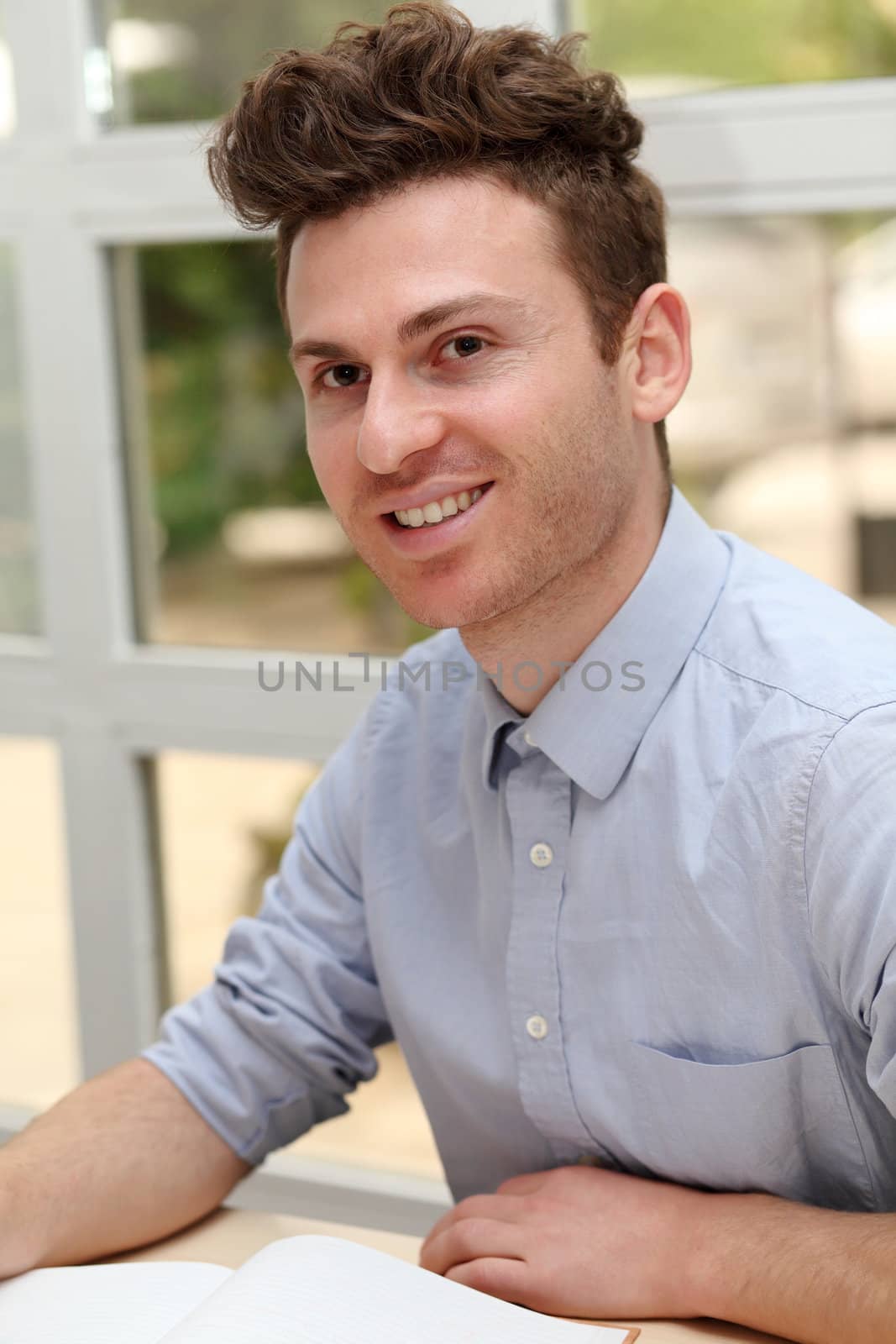 Young adult man writing notes with pen