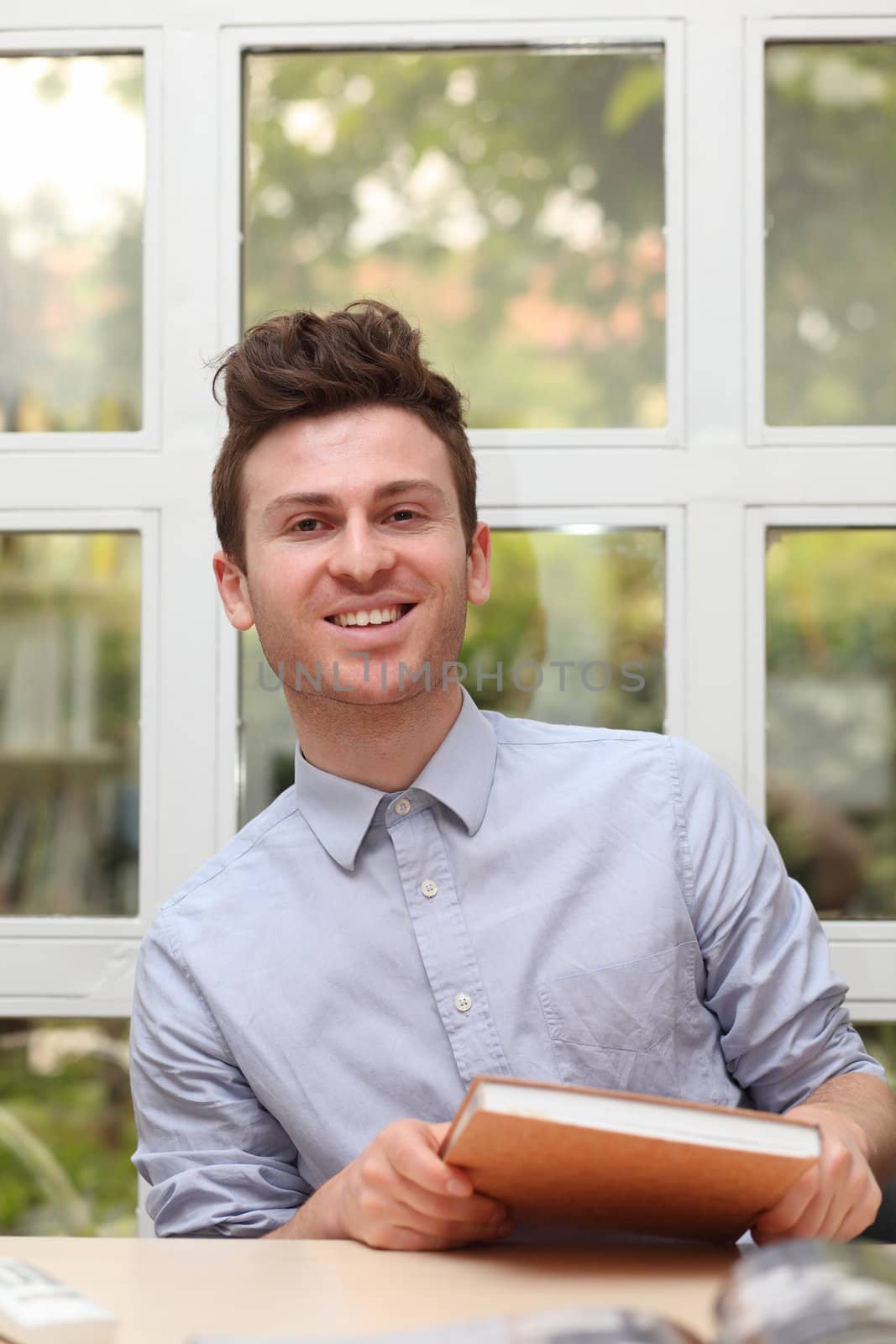 Young adult man holding notes book