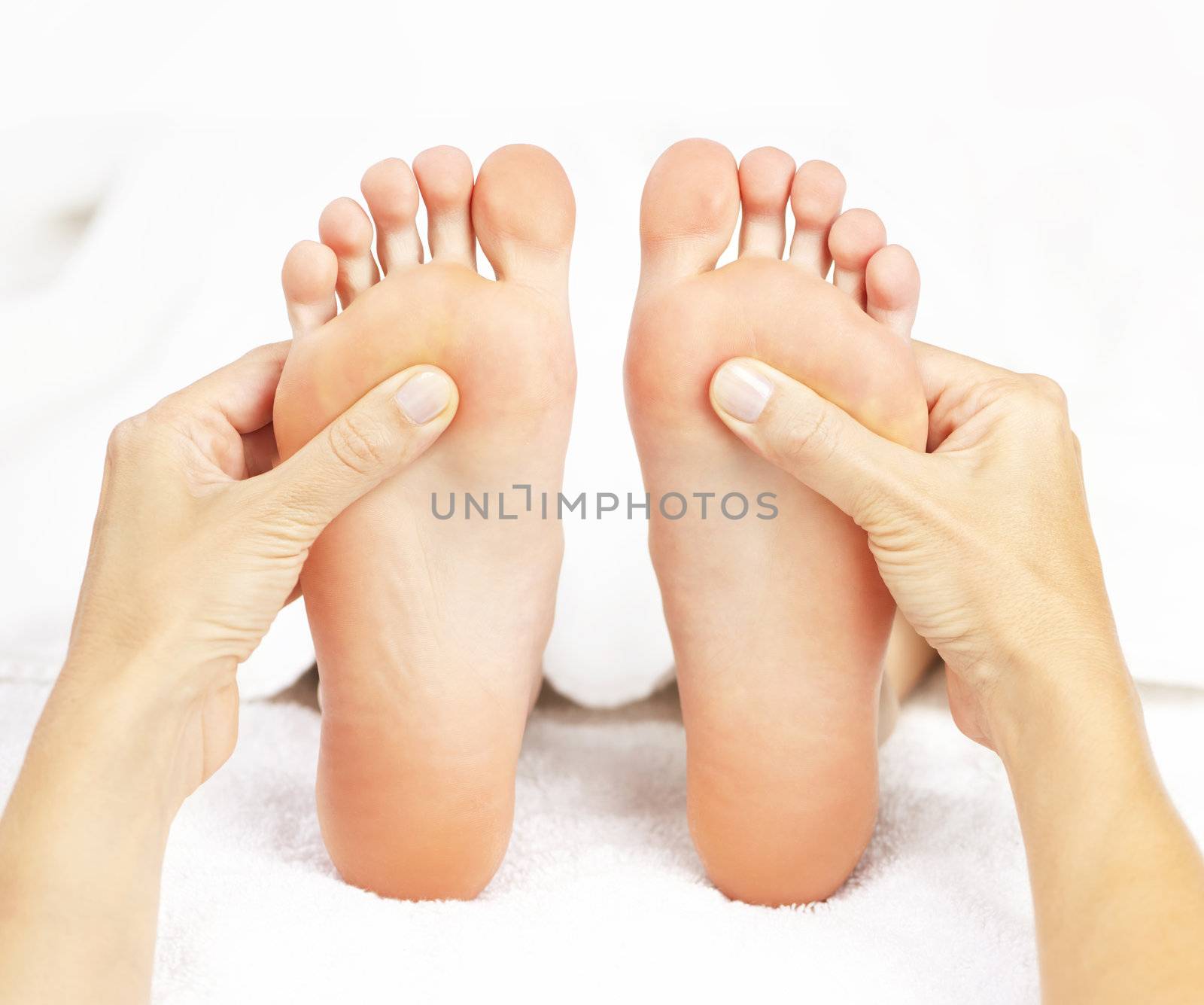 Female hands giving massage to soft bare feet
