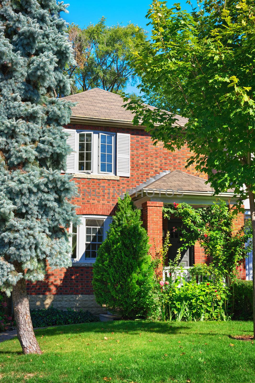 City home in red brick exterior with garden