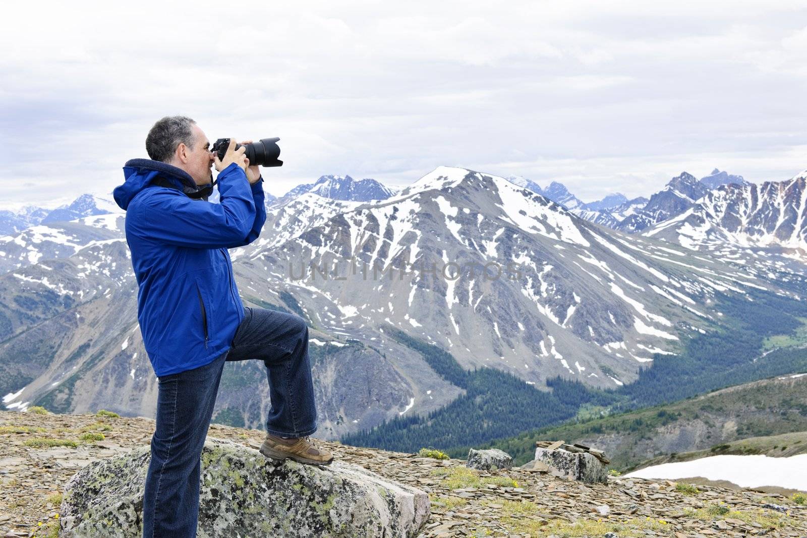 Male photographer taking pictures in Canadian Rocky Mountains in Jasper National Park