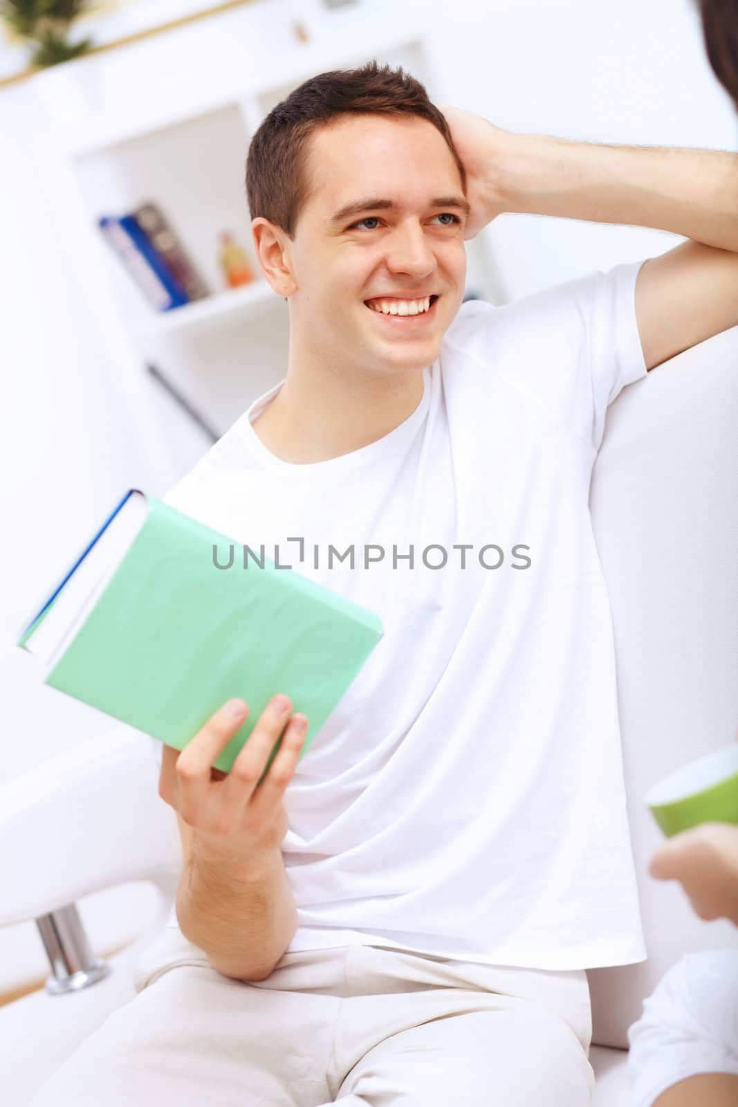 Young handsome man at home with a book