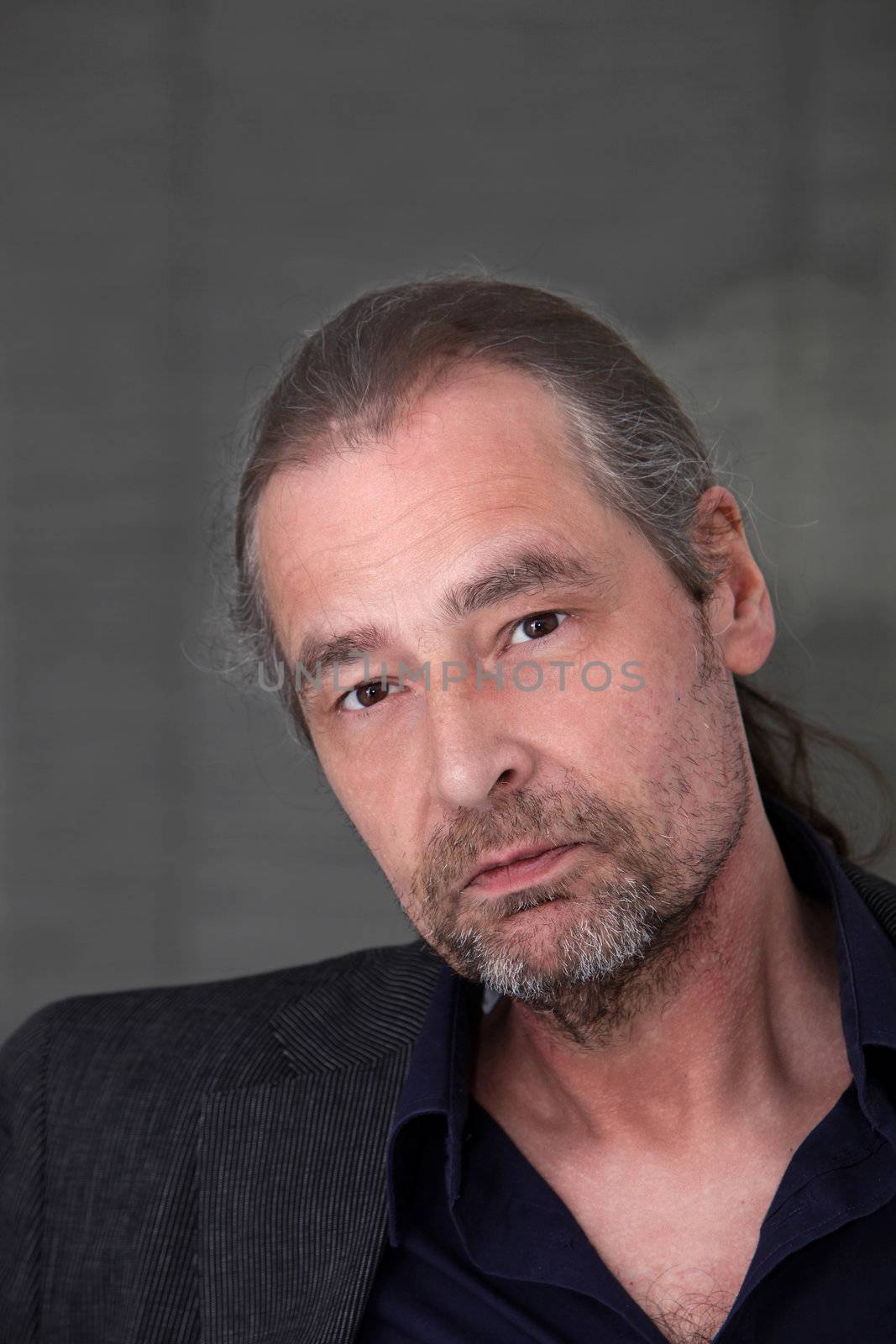 Old man with long hair, beard and mustache looking in a front view shot