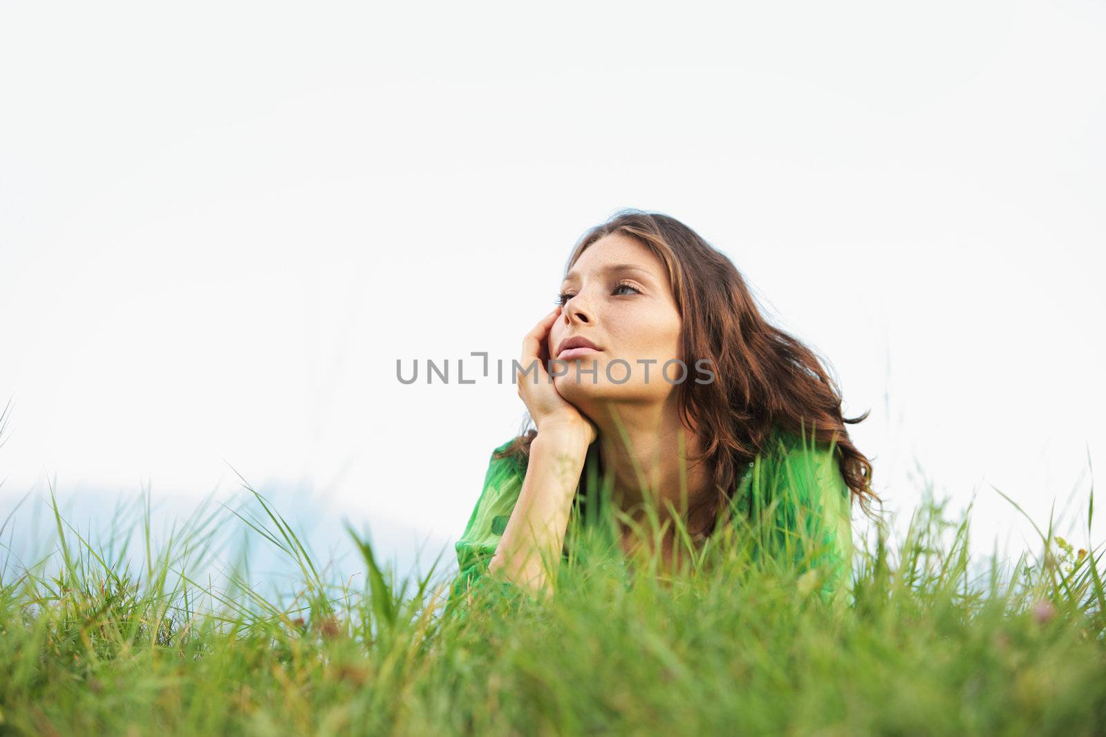 Young woman lying on the grass looking at the sky