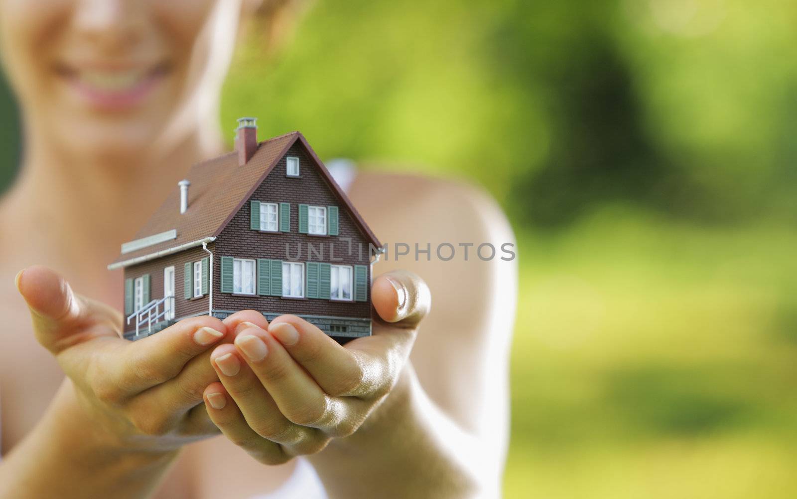 Young beautiful woman offering a house