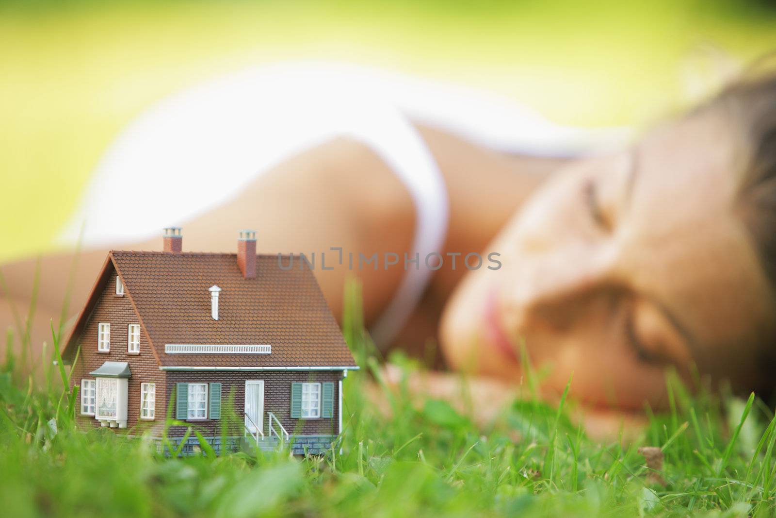 Young woman on a lawn dreaming of her new home