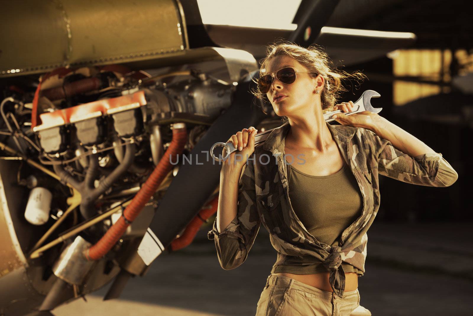 Woman airplane mechanic. Airplane on the background