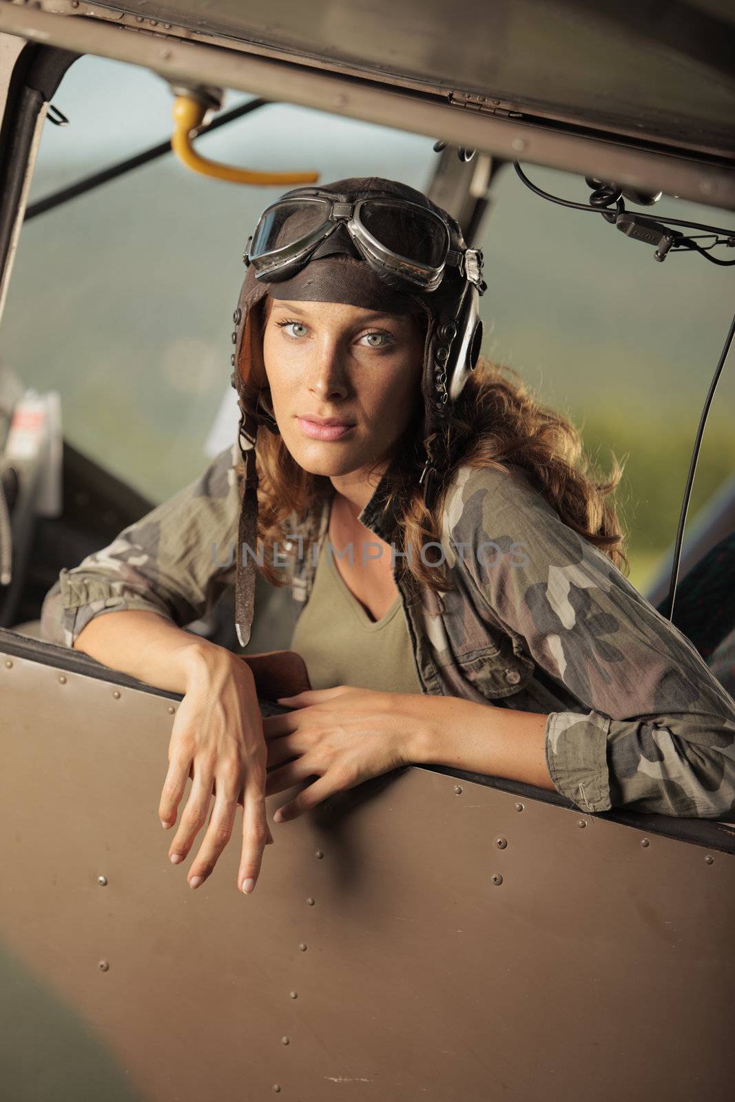 Portrait of young woman pilot in a military airplane