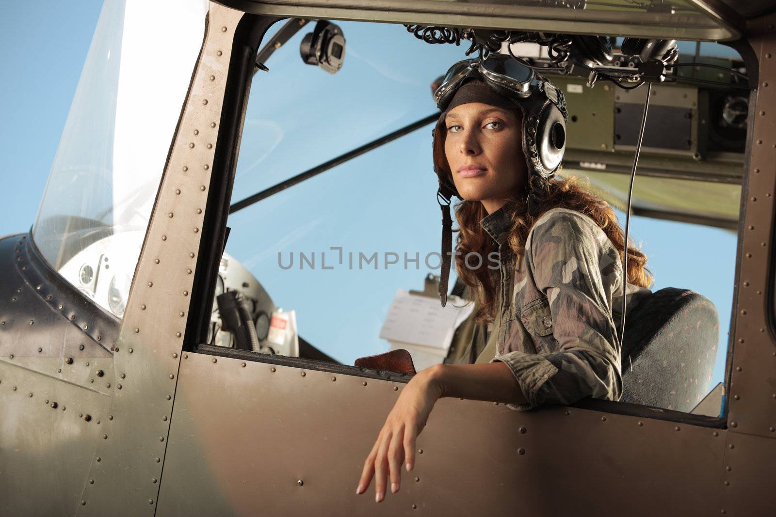 Portrait of young woman pilot in a military airplane
