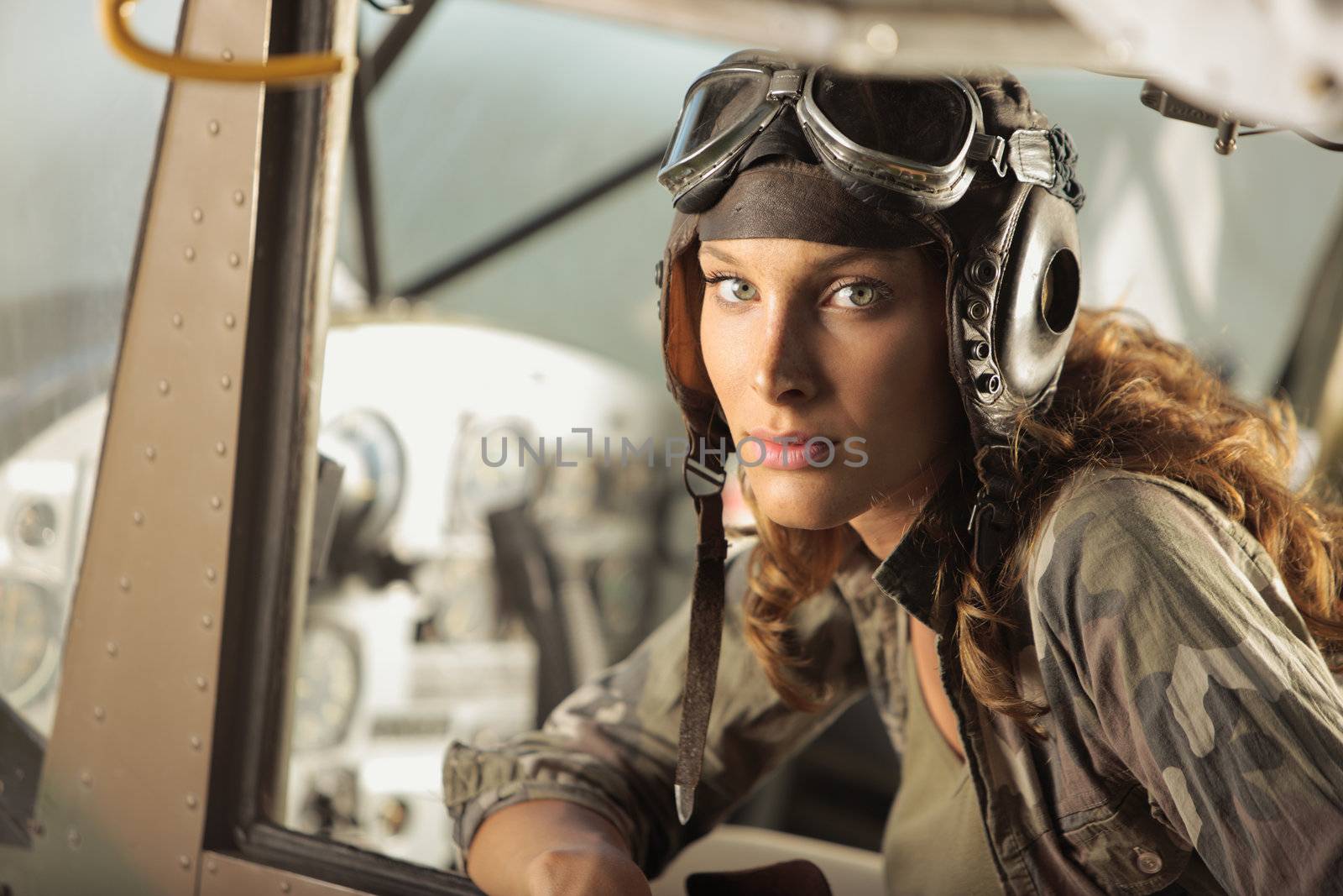 Portrait of young woman pilot in a military airplane