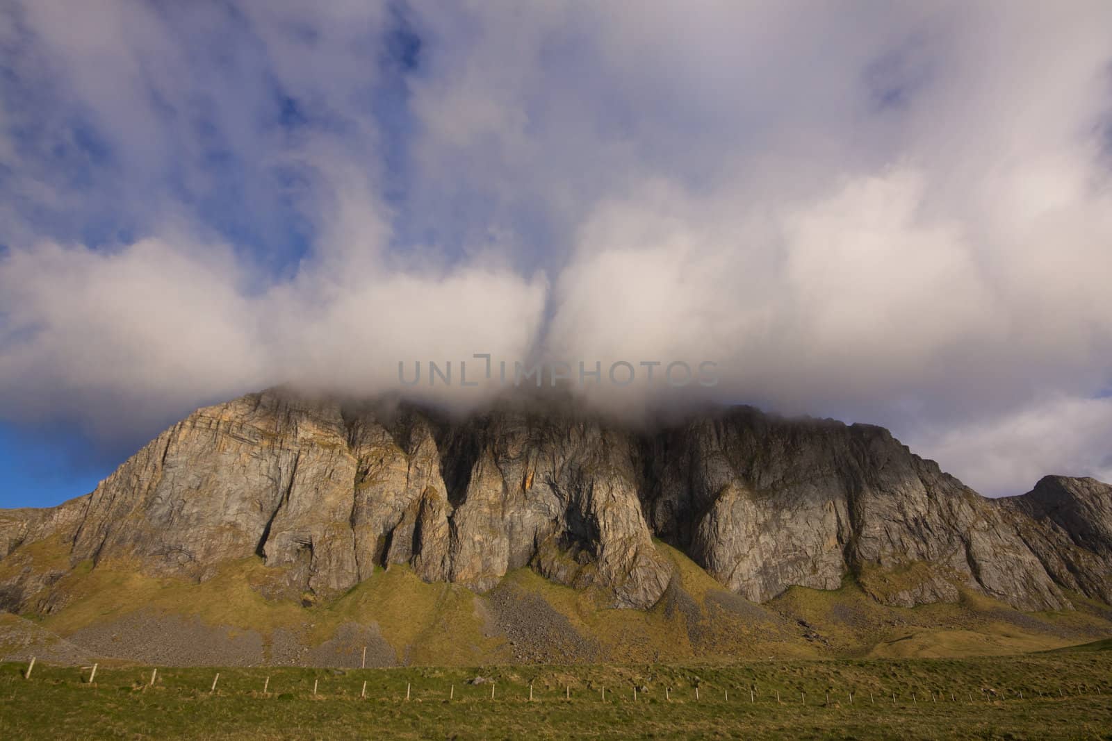 Dramatic view of cloudy cliffs on remote island of Vaeroy in north Atlantic, Lofoten islands, Norway