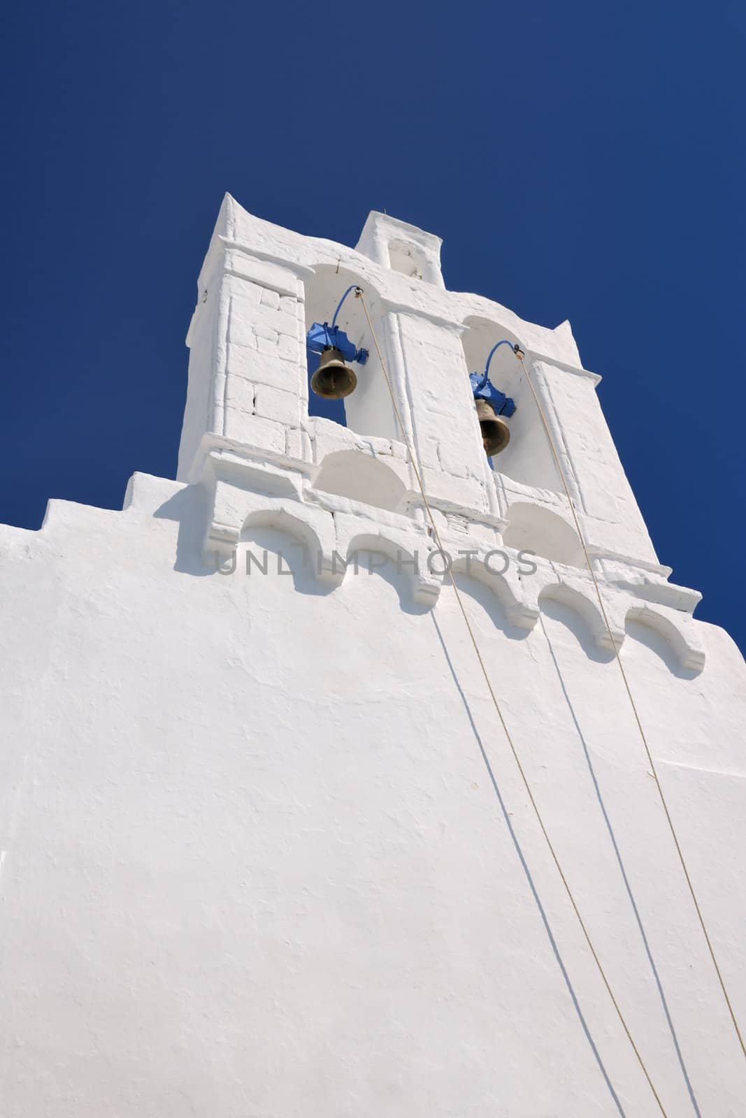 Belfry of an Orthodox church on the Greek Aegean island of Sifnos, against a blue sky