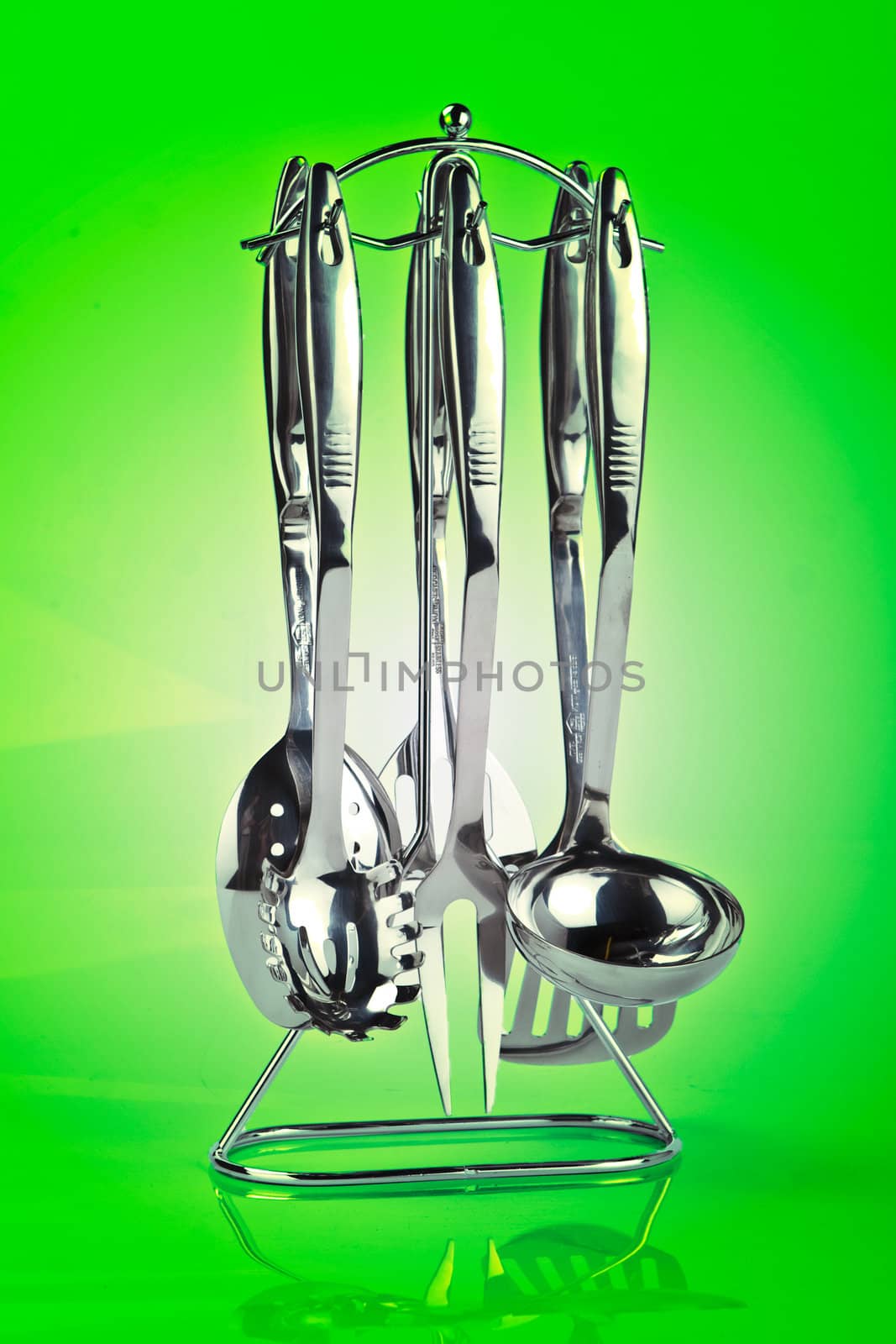 Kitchen utensil set standing against green background 