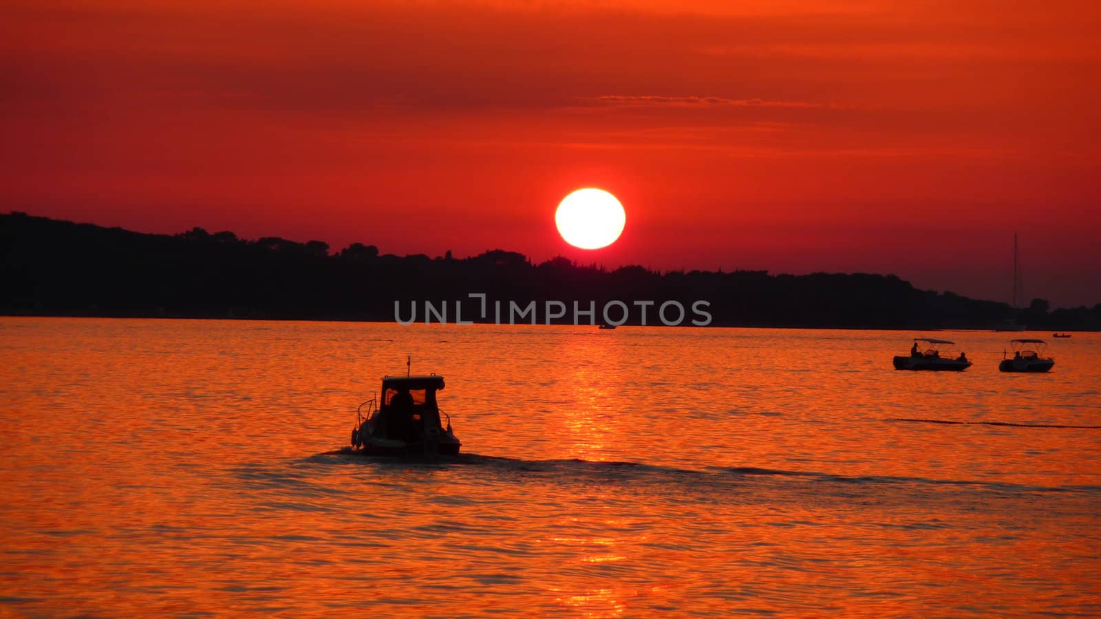 Fishermen silhouette on sea at red sunset near Brioni nationl park