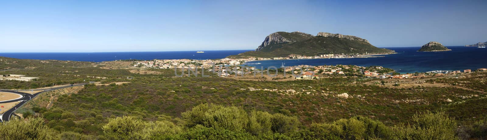 View at beautiful Sardinian landscape with island and a town. Panorama